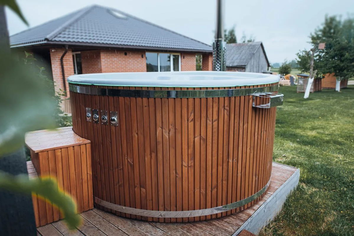 Integruotas stiklo pluošto kubilas ant medinės terasos sodyboje